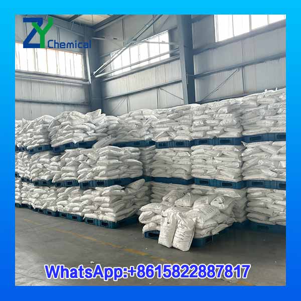 Vue panoramique des stocks massifs de sacs de 25 kg de soude caustique en perles industrielles (99% pure)